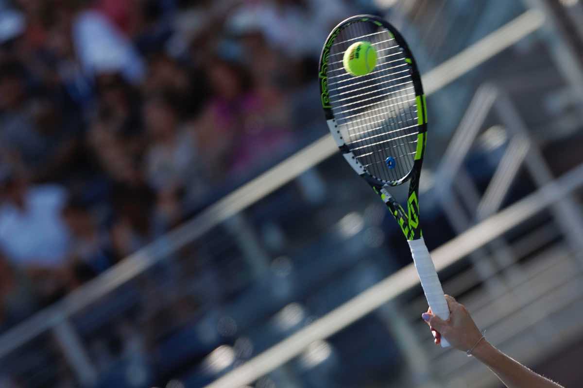 Racchetta colpisce una pallina da tennis