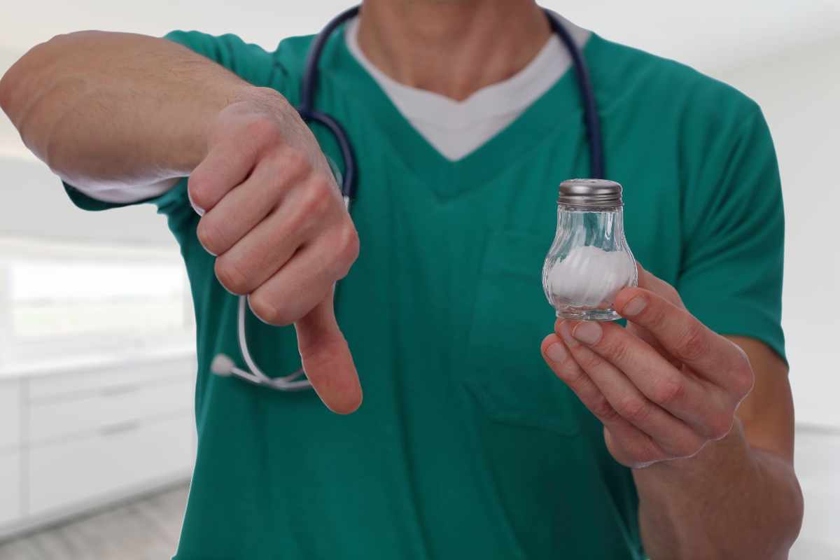 medico con boccetta di sale in mano e pollice verso