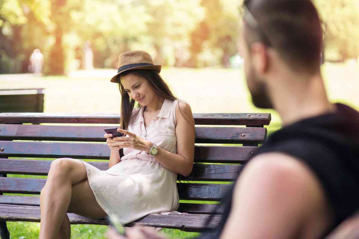 ragazzo guarda una ragazza seduta su una panchina