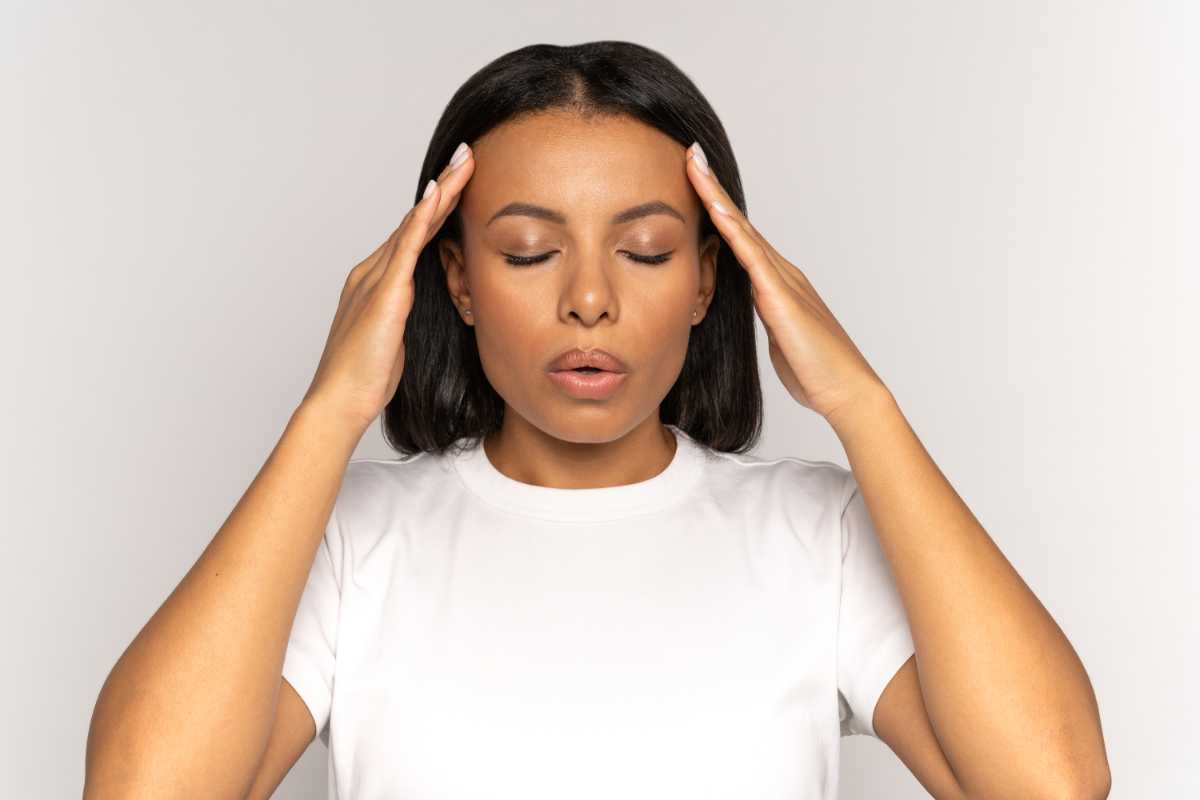 donna con le mani sulla fronte per lo stress