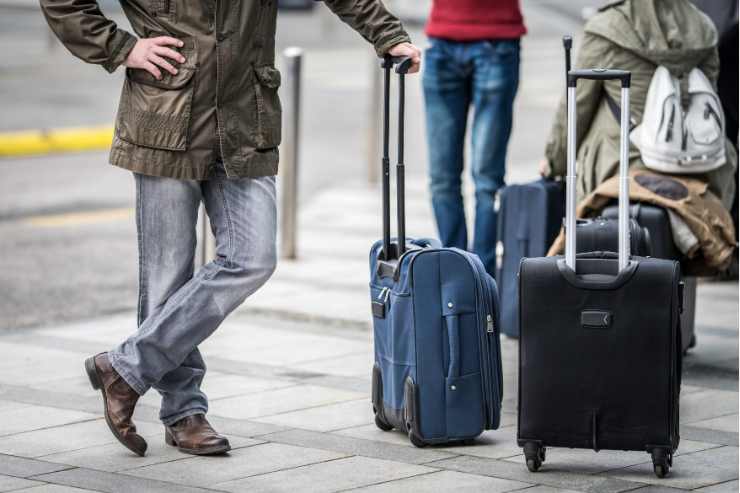 viaggiatori con valigie in partenza per una delle mete Weekend di ottobre 