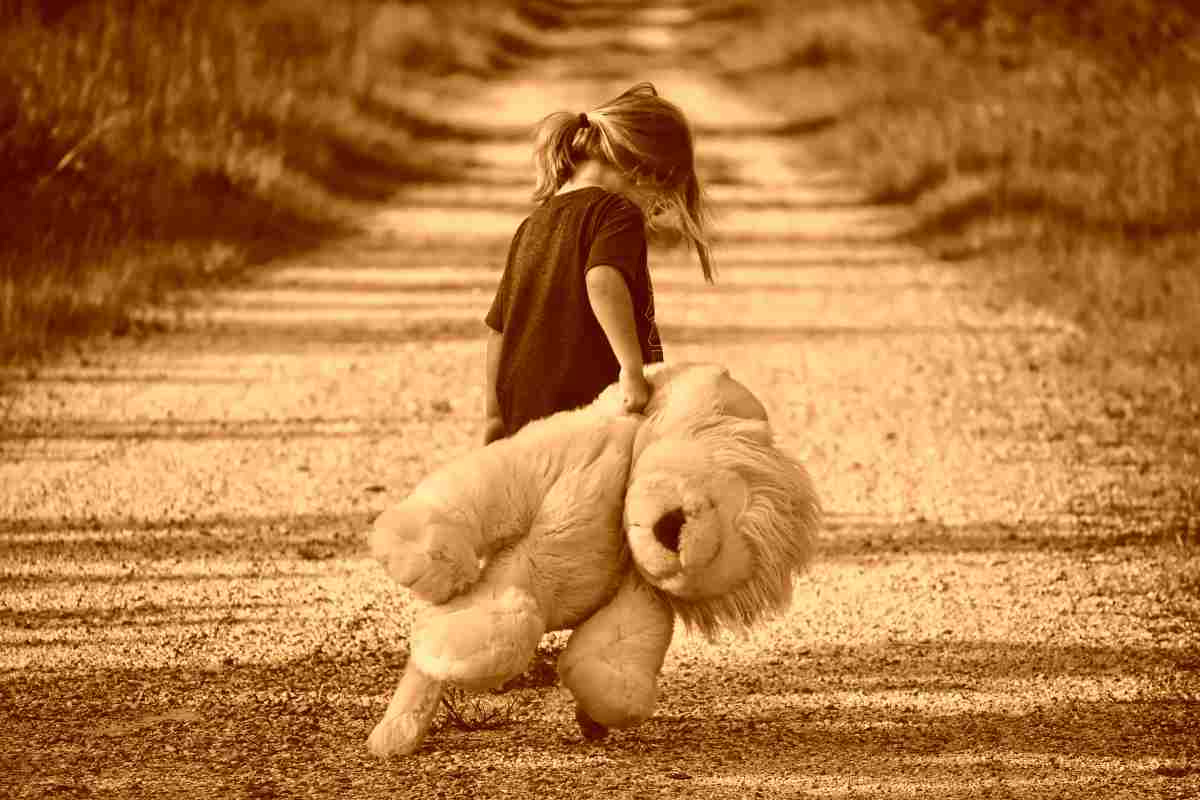 Bambina con un leone di peluche 