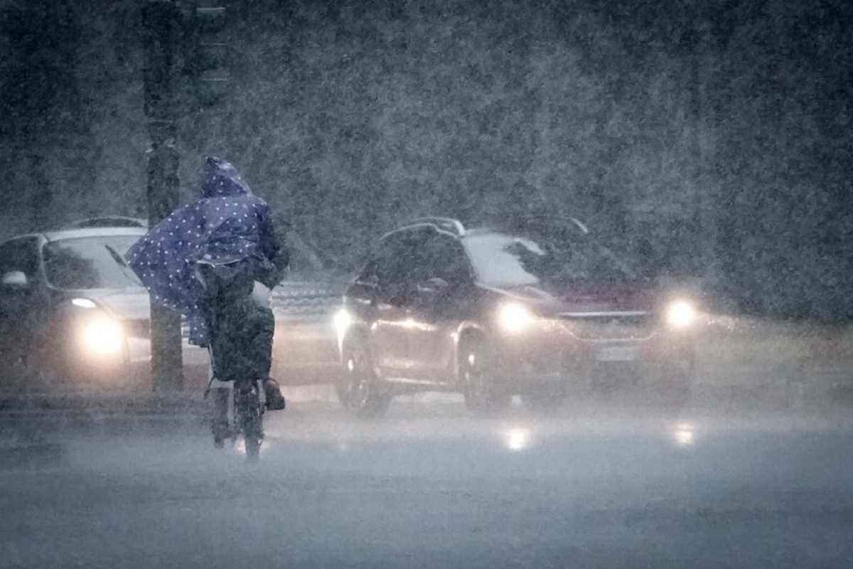 un uomo in bici sotto la pioggia