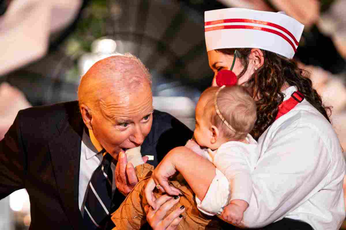 Joe Biden morde per gioco il piedino di un bambino ad un evento a Washington 