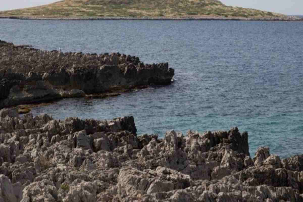 Panoramica di alcuni scogli, il mare e un'isola sullo sfondo