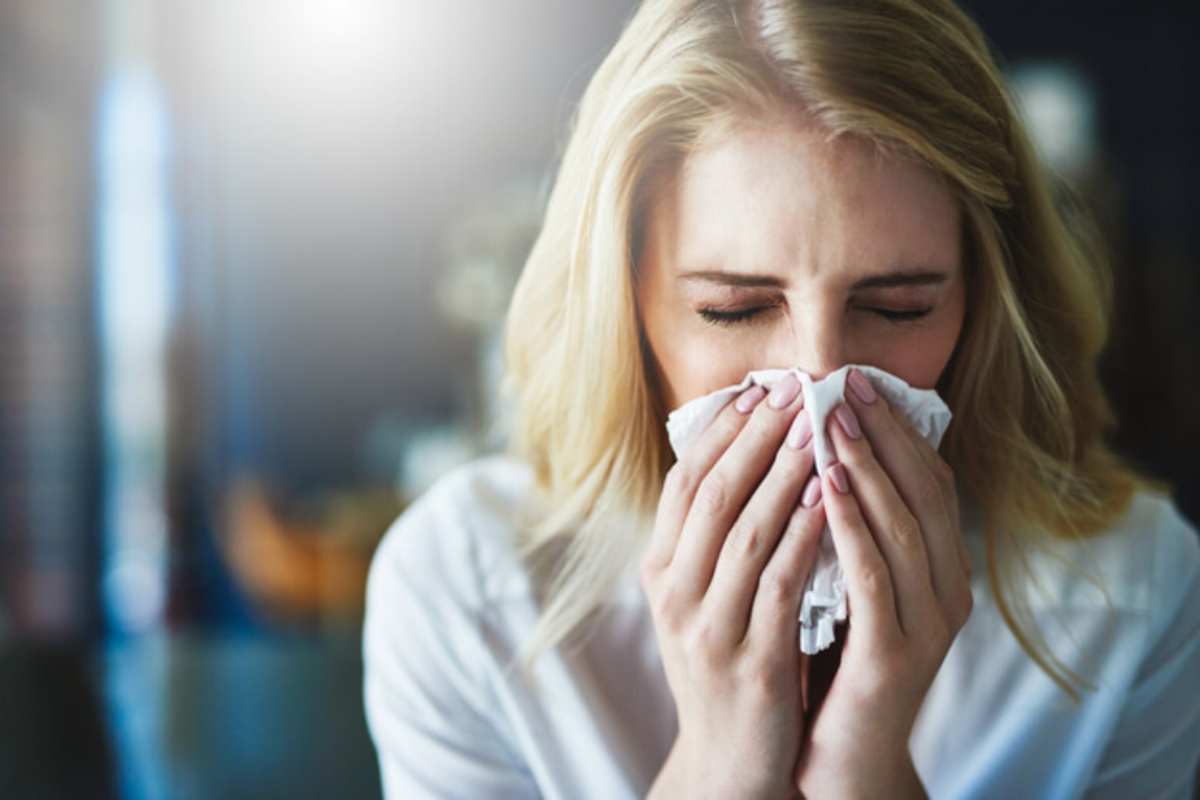 Una donna che si soffia il naso per un'allergia