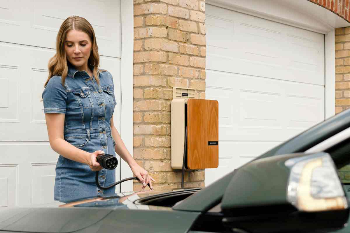 Una donna che carica un'auto elettrica