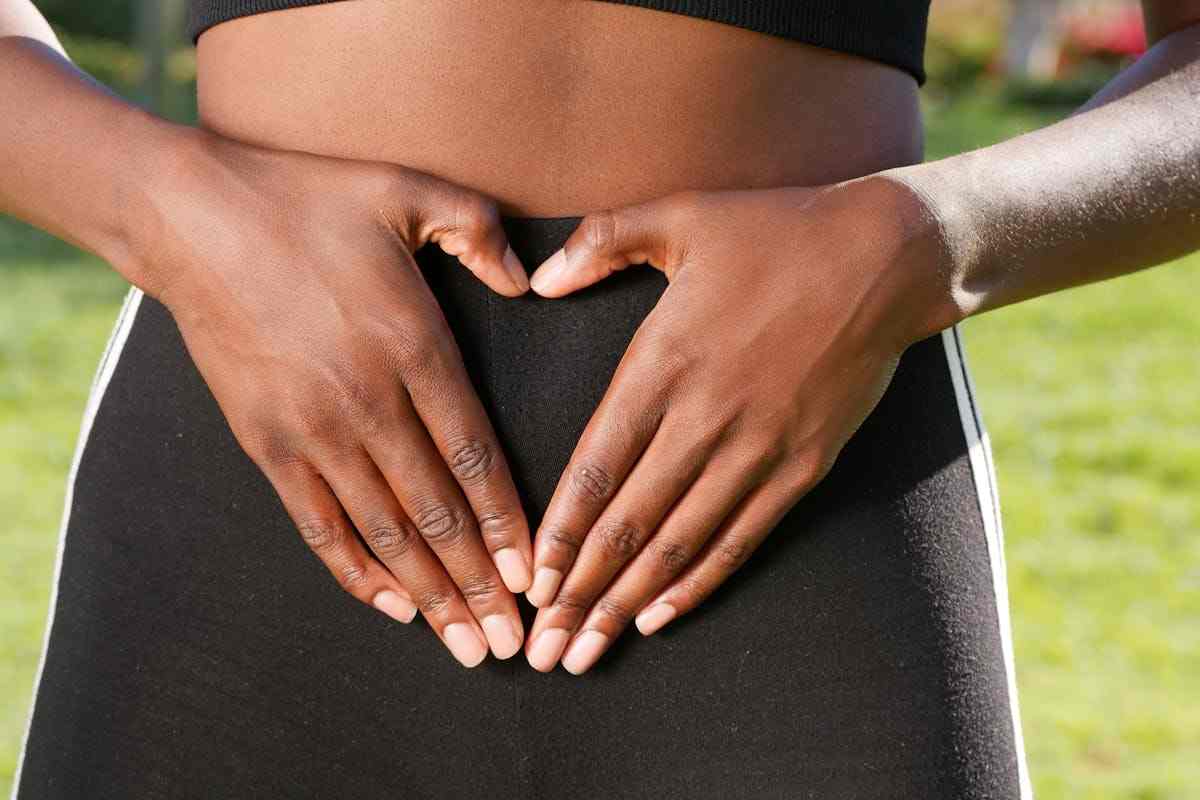 una ragazza forma un cuore con le mani sull'intestino