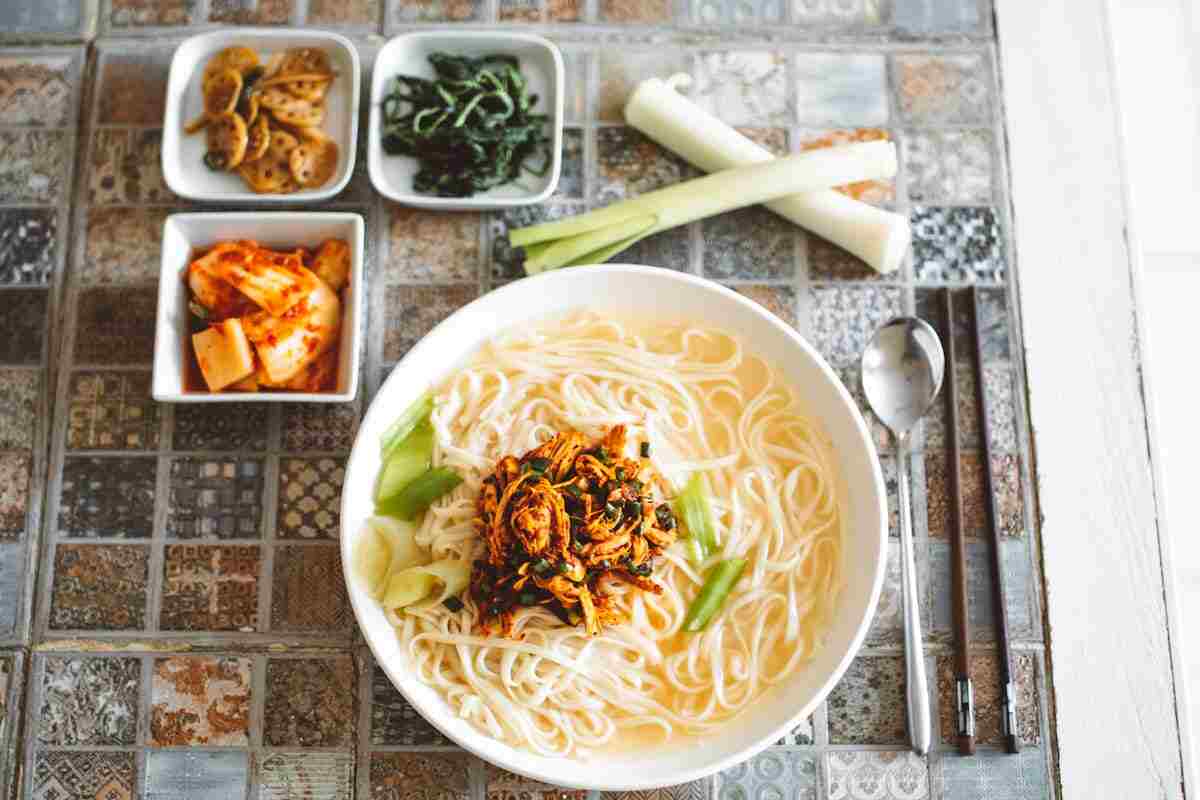 Un piatto di kimchi coreano con altre verdure e dei noodles