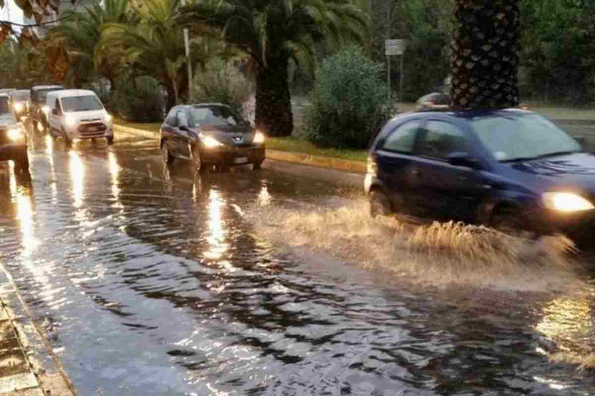 Auto passano su una strada allagata per le forti piogge