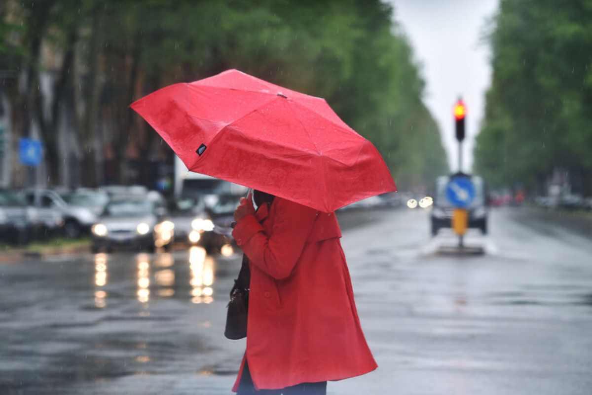 Donna si protegge dalla pioggia con un ombrello