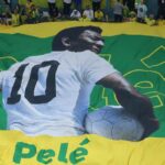 Enorme striscione di Pelè con il pallone in mano e i colori del Brasile sullo sfondo