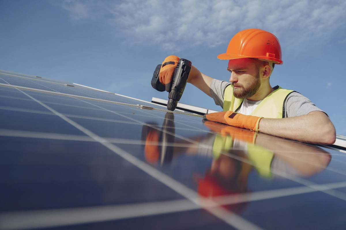 Un tecnico che monta pannelli fotovoltaici