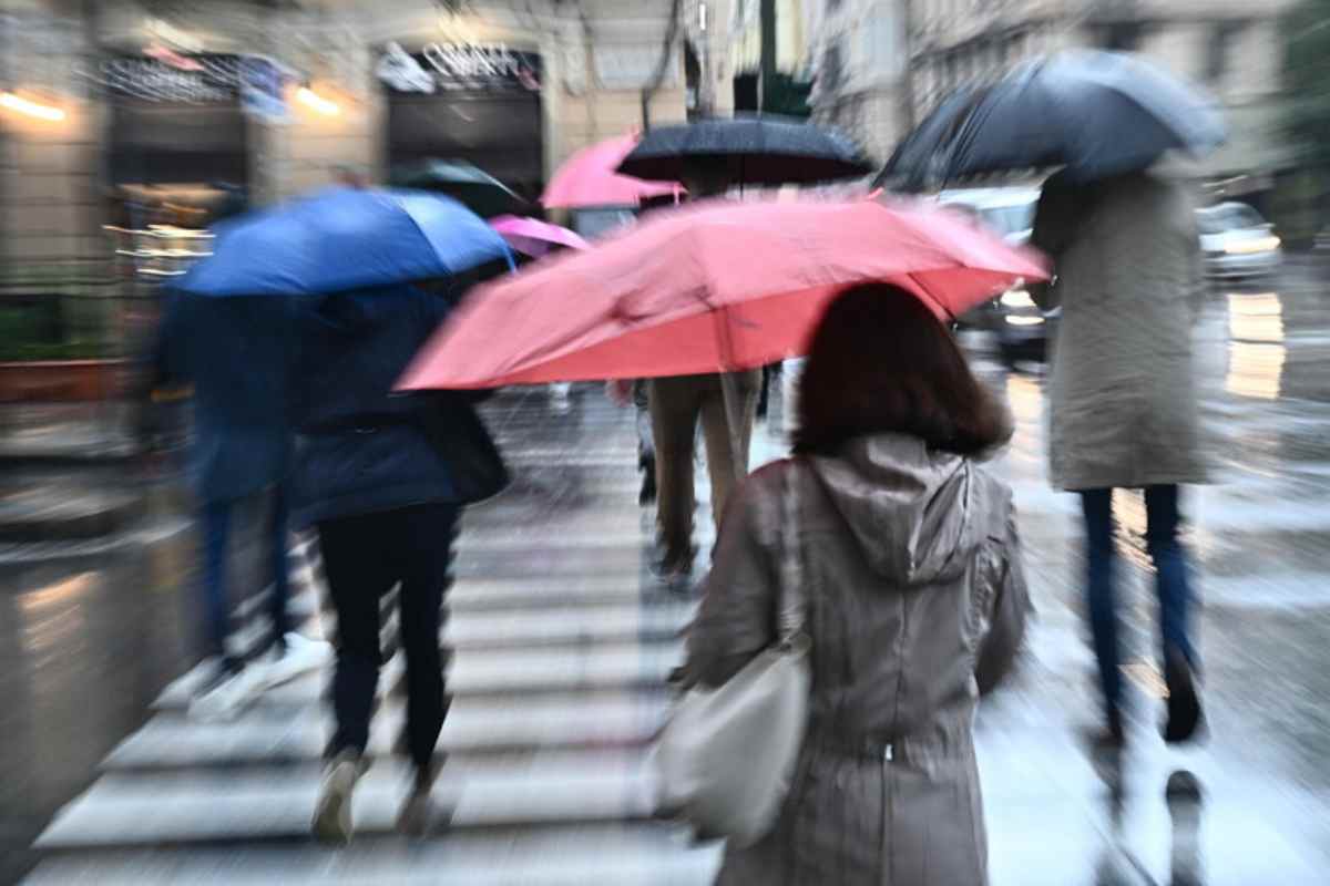 donna si protegge con l'ombrello dalla pioggia