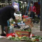 Una signora cerca del cibo nella spazzatura