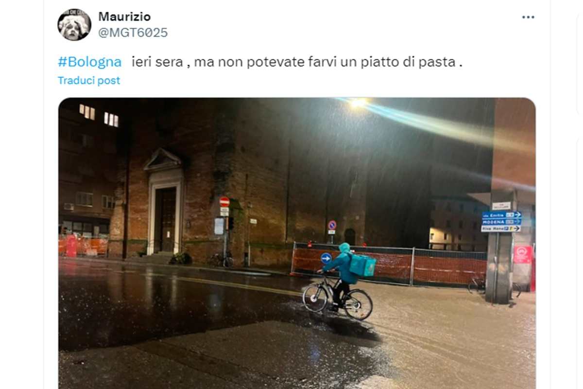 Un rider che consegna pizze, malgrado l'alluvione