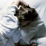 Foto dall'alto di una donna che dorme nel proprio letto