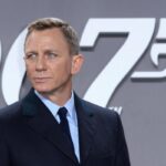 L'attore Daniel Craig con il poster di 007 alle sue spalle