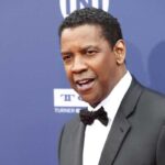 L'attore Denzel Washington, in smoking, sulla passerella di un festival