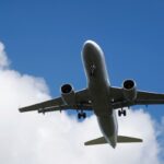 Un aereo di linea in volo fotografato dal basso, con un cielo sereno sullo sfondo