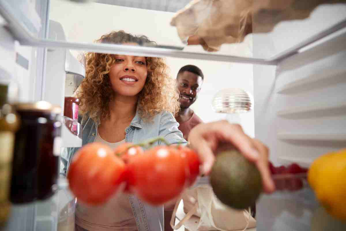 donna prende alimenti nel frigo