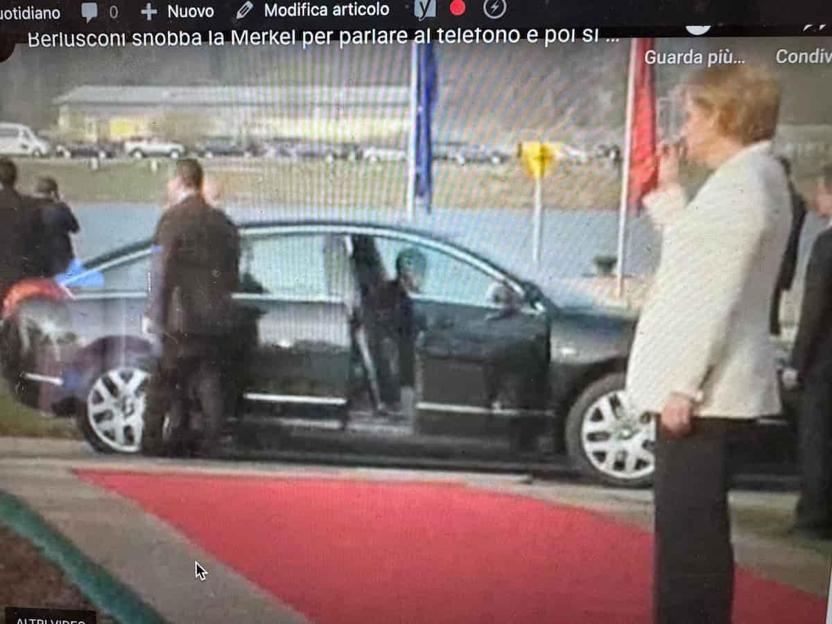 Angela Merkel aspetta Berlusconi che parla al telefono