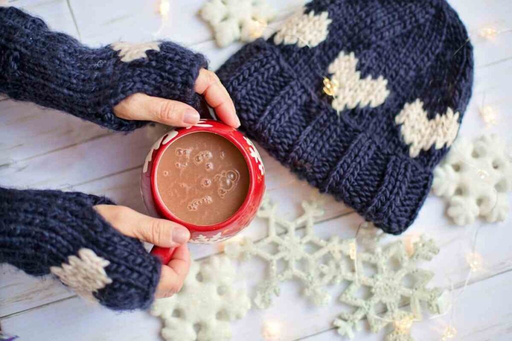 una tazza di cioccolata calda con cappello e guanti