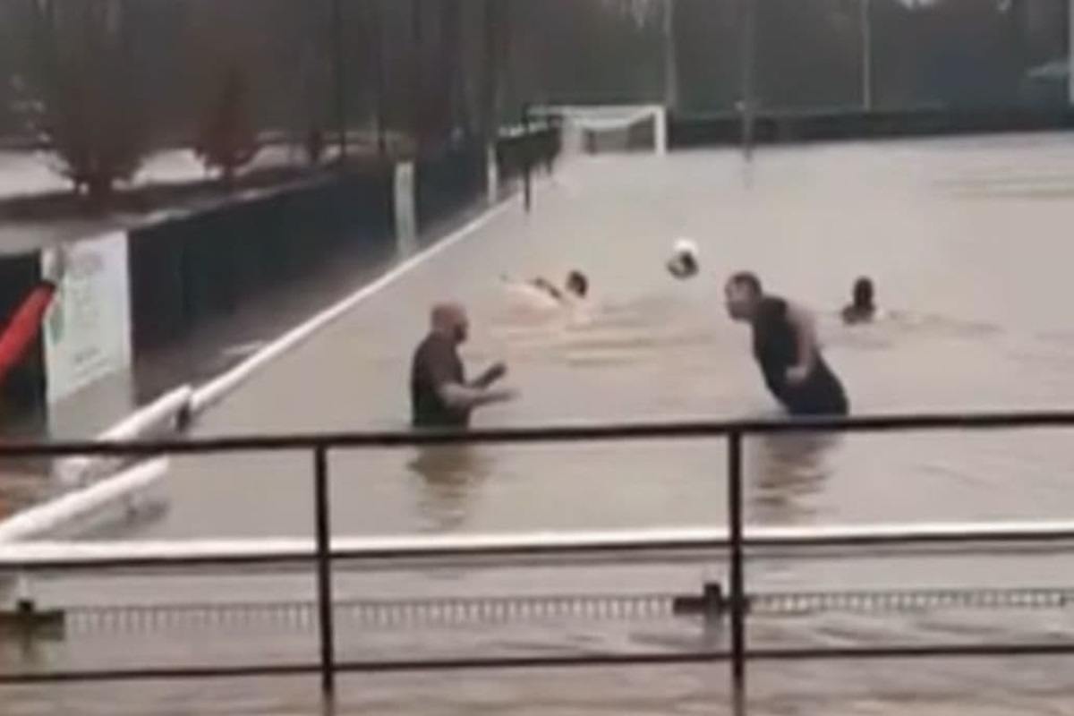 I calciatori che si allenano malgrado il campo allagato