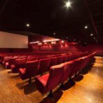 Panoramica di una sala cinematografica con le luci accese