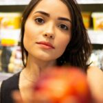 Ragazza al supermercato che mostra una mela