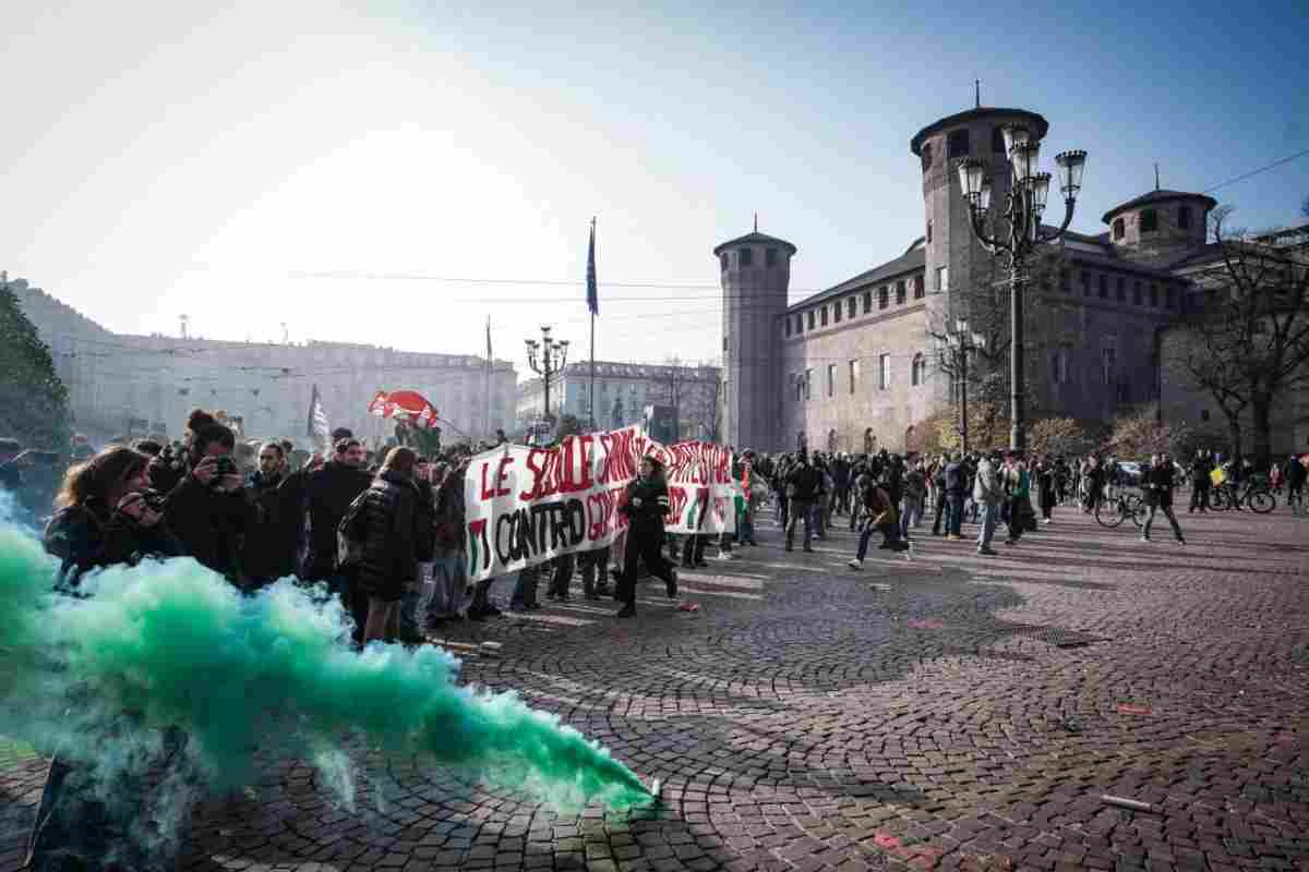 Scontro tra antagonisti e Polizia a Torino, manifestanti bruciano i cartelli con le facce di Meloni e Salvini