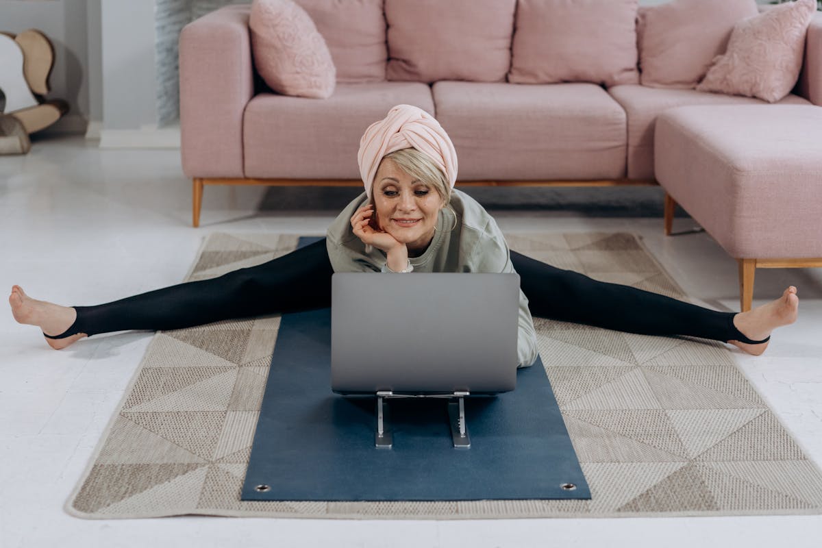 donna matura guarda il pc mentre fa yoga