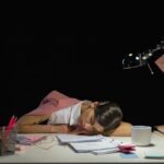 una ragazza dorme sulla scrivania