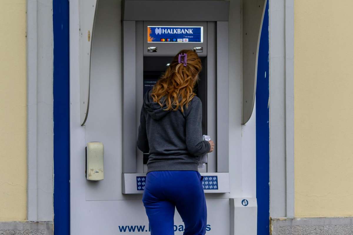 Una ragazza preleva al bancomat