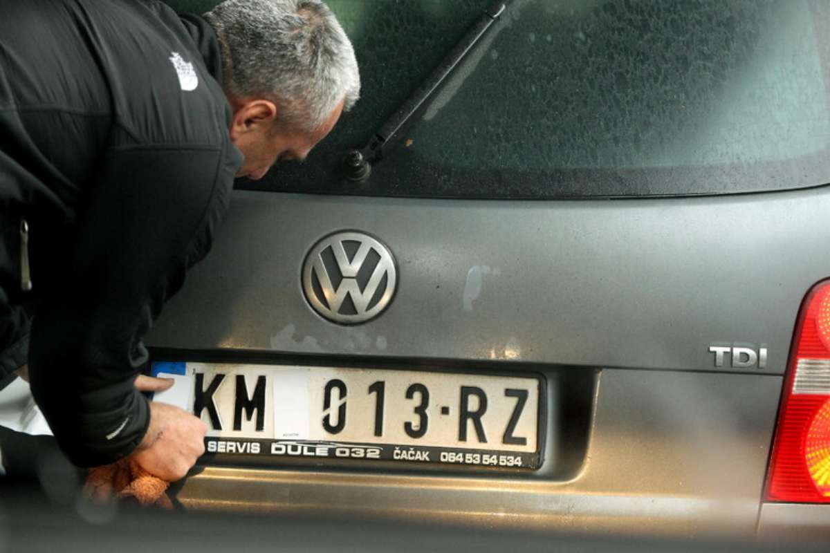 uomo sistema una targa di auto