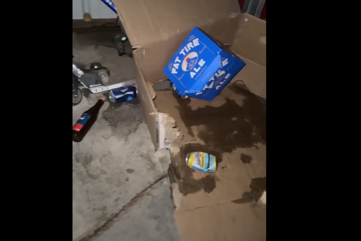 Lattine di birra vuote e casse distrutte dentro un garage