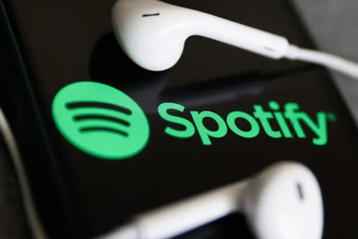 Il logo di Spotify su un cellulare e un paio di cuffie