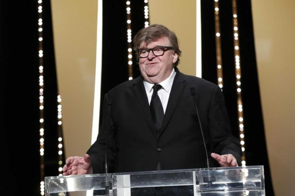 Il regista Michael Moore ai microfoni durante una conferenza