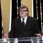 Il regista Michael Moore ai microfoni durante una conferenza