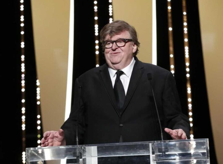 Il regista Michael Moore ai microfoni durante una conferenza