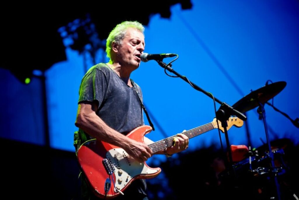 Rudy Rotta suona la chitarra e canta su un palco durante una sua esibizione dal vivo