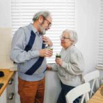 due persone mature in cucina bevono un frullato