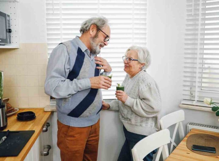 due persone mature in cucina bevono un frullato