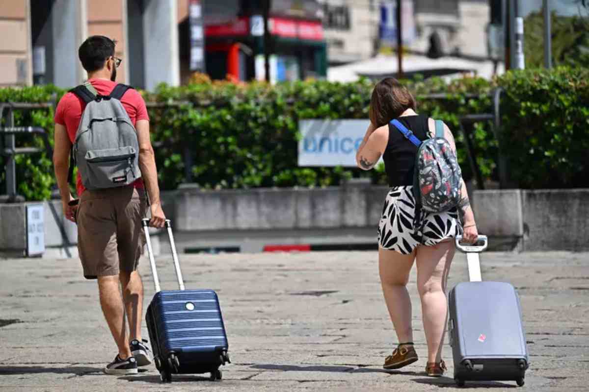 Due turisti con la valigia in strada