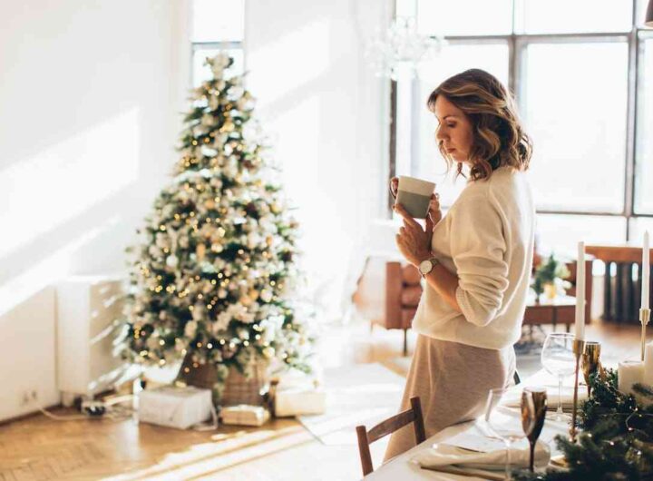 ragazza beve una tisana davanti a un albero di Natale