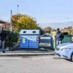 polizia vicino a cassonetti dei rifiuti