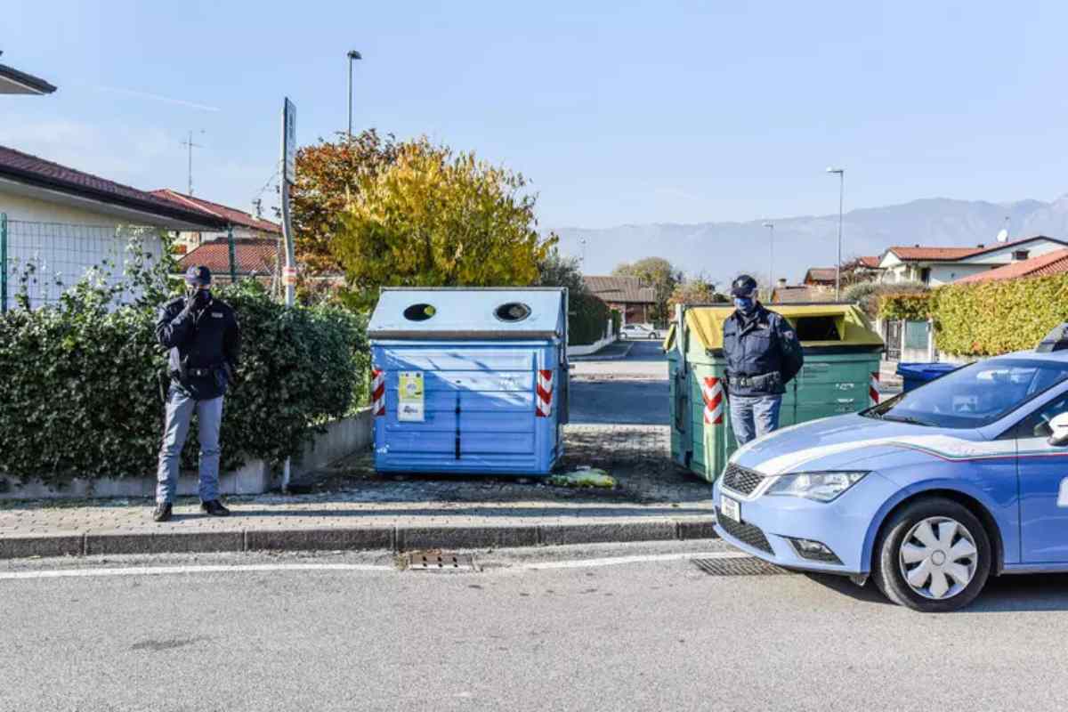 polizia vicino a cassonetti dei rifiuti