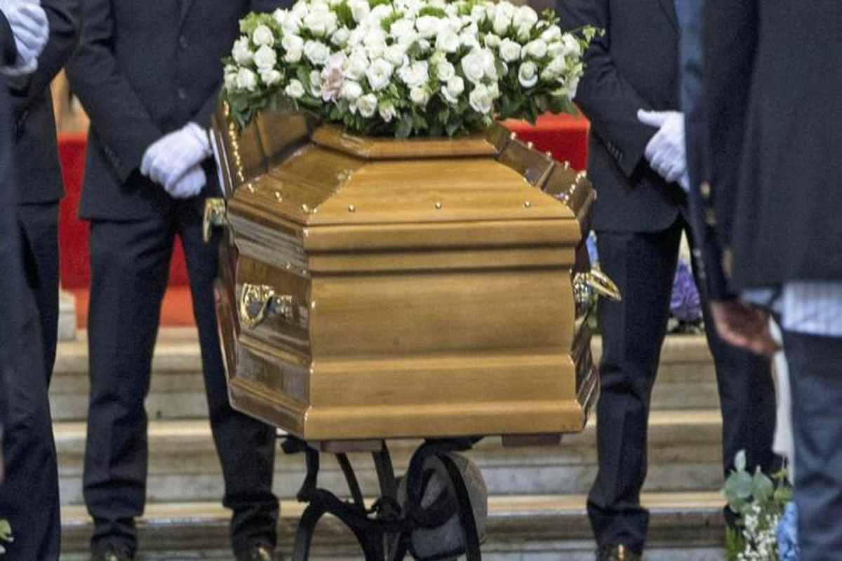 Una bara con dei fiori durante un funerale 