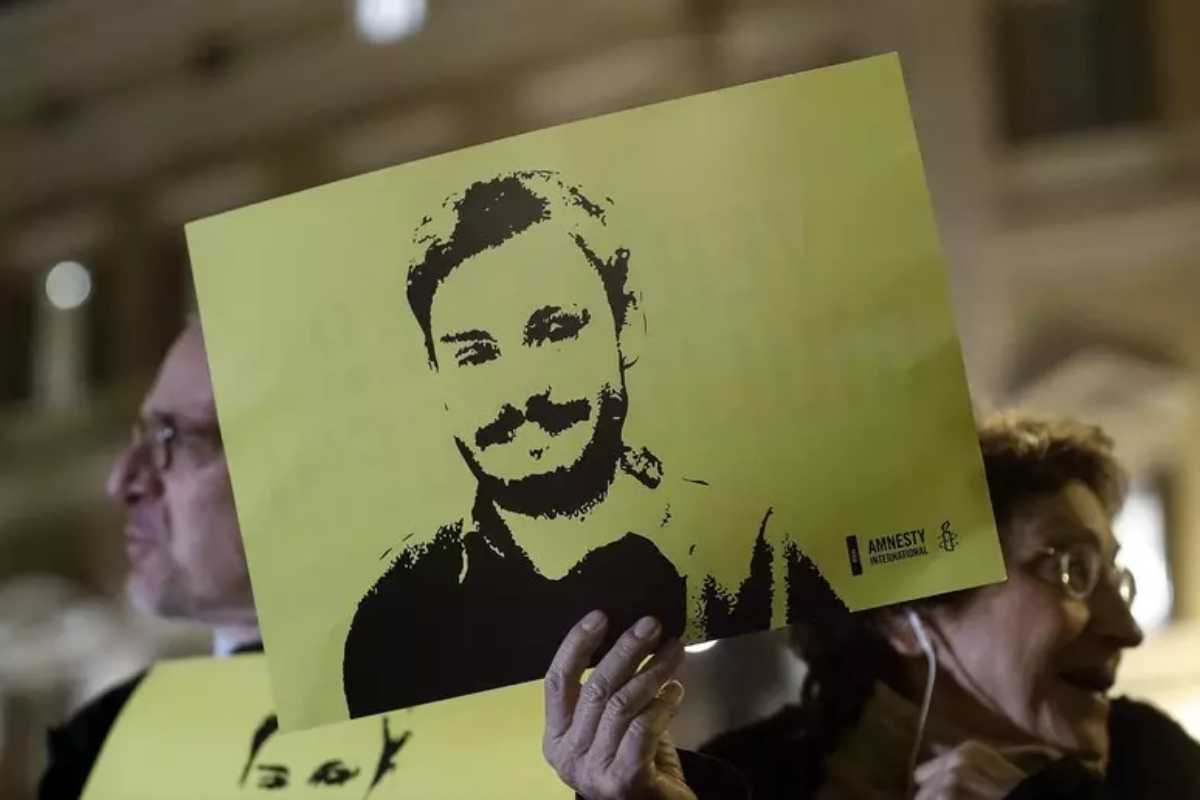 Un simpatizzante di Amnesty International mostra un cartello con il volto di Regeni