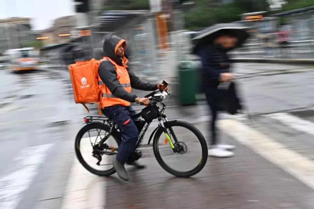 Un rider al lavoro sotto la pioggia